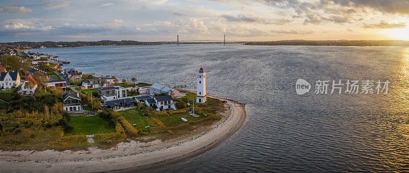 Strib灯塔，丹麦海岸上风景如画的历史灯塔，坐落在宏伟的Den Nye Lillebæltsbro(新小带桥)的背景下。米德尔法特海滩上的灯塔。